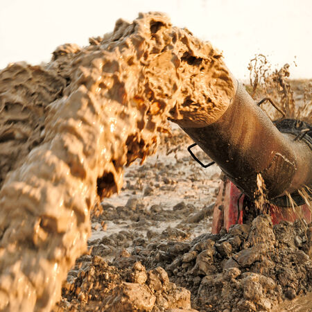 Large water pump gushing from an old rusty pipeline  の写真素材