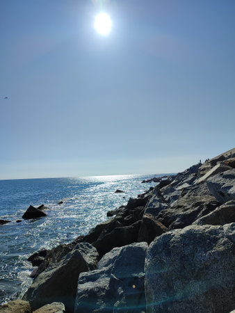 oceanview with rocks, waves and sun reflectionの写真素材