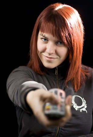 Girl zapping television channels with the remote control device.