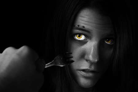 Picture of an intimidated girl. Eating disorders/fork.の写真素材