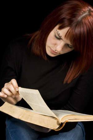Girl turning a page in a dictionary. Shot in studio.の写真素材
