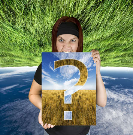 Redhead girl holding a canvas with a question mark.Shot in studio. Composite background.