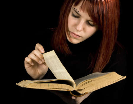 A beautiful redhead girl studying from a bookの写真素材