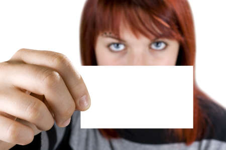 Redhead girl holding a business card on a nature background. Close-up of the hand with the empty...