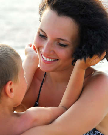 Beautiful young adult mather holding on knees  four years  sonの写真素材