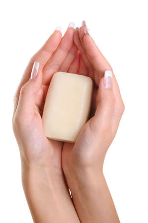 Beautiful female hands hold the white soap - over white backgroundの写真素材