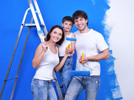 Happy smiling family with paintbrushes doing renovation - indoorsの写真素材