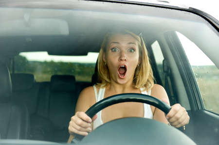 scared woman shouts driving the car - outdoorsの写真素材