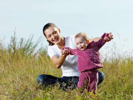 Happy young beautiful mather with smiling beby on nature outdoorの写真素材
