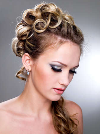 Beautiful young bride with blue make-up and ringlet wedding hairstyle