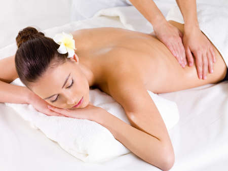 Massage for the back of young beautiful woman in spa salon - indoors Massage for the back of young beautiful woman in spa salon - indoors