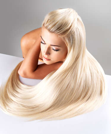Beautiful woman with long straight blond hair. Fashion model posing at studio. Beautiful woman with long straight blond hair. Fashion model posing at studio.