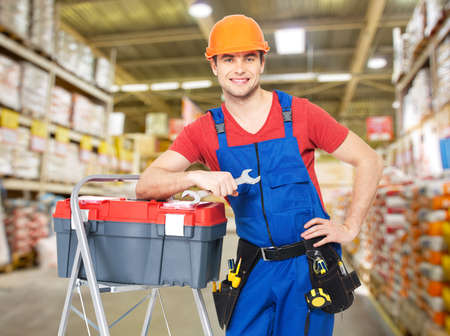 Portrait of smiling manual worker with tools at warehouse