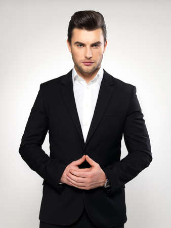 Fashion young businessman black suit casual  poses at studioの写真素材