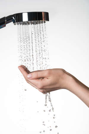 Closeup female hands under the stream of  water from shower - skin care conceptの写真素材