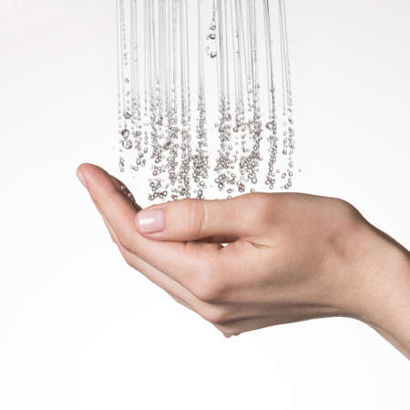 Closeup female hands under the stream of splashing water - skin care conceptの写真素材
