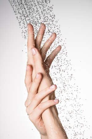 Closeup female hands under the stream of splashing water - skin care conceptの写真素材