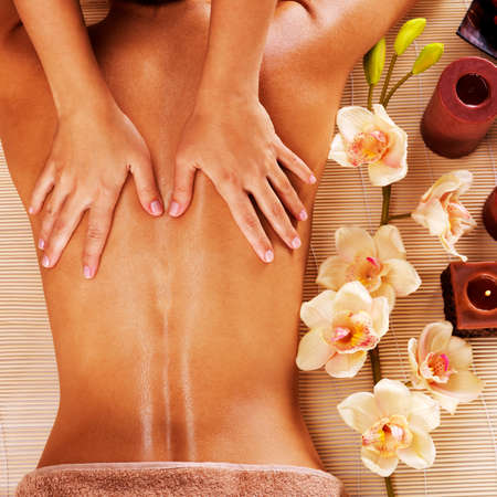 Masseur doing massage on woman back in the spa salonの写真素材