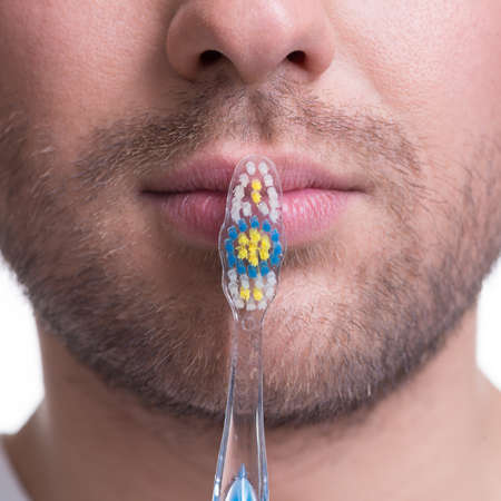 Ð¡lose-up portrait of  man mouth with a toothbrush - isolated on white.