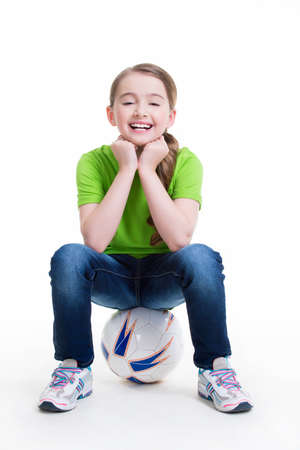 Portrait of a happy little girl sitting on the ball - isolated on white.の写真素材