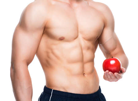 Young man with perfect body holding red apple in his hand - isolated on white background.の写真素材