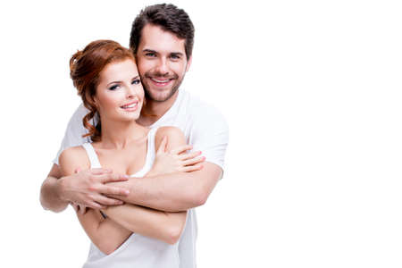 Portrait of beautiful smiling couple posing at studio over white background.の写真素材