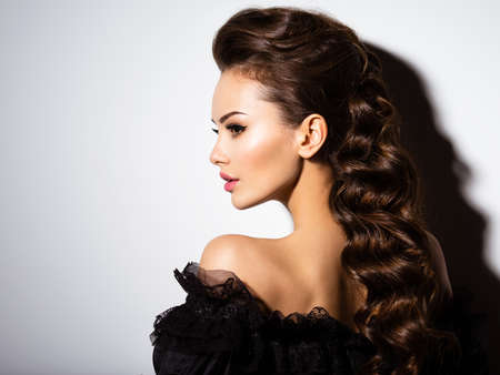 Beautiful face of an young sexy woman in black dress  posing at studio on white backgroundの写真素材