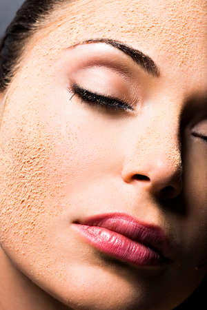 Face of a woman with cosmetic powder on skin - isolated on whiteの写真素材