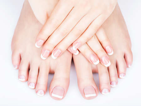 Closeup photo of a female feet with white french pedicure on nails. at spa salon. Legs care conceptの写真素材