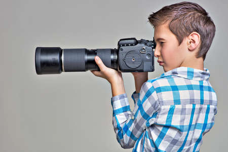 Teen boy  with dslr camera photographing. Boy with camera taking pictures. Profile portrait.