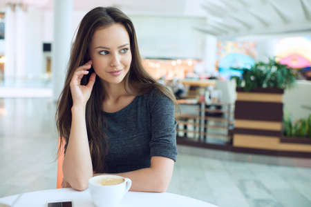 woman drinking coffee in the morning at restaurant soft focus. Elegant woman in a coffee breakの写真素材