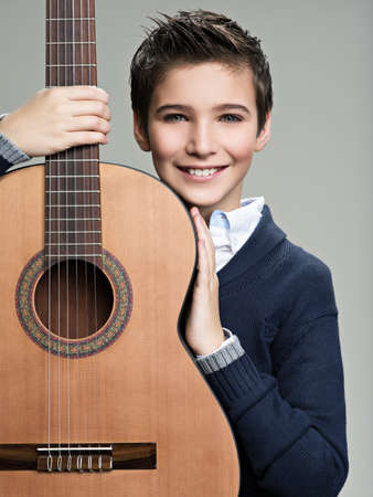 Smiling boy with guitar. Teenager boy with classic wooden acoustic  guitarの写真素材
