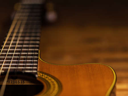 CLassic wooden guitar body close-up view is on the wood floorの写真素材