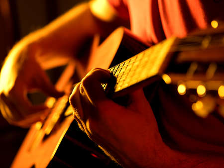 man playing classic guitar on a stage musical concert close-up viewの写真素材
