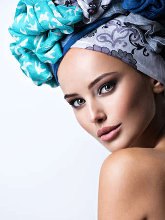 Sexy portrait of a beautiful girl with turban on head. Bright makeup. Pretty closeup face of a fashionable womanの写真素材