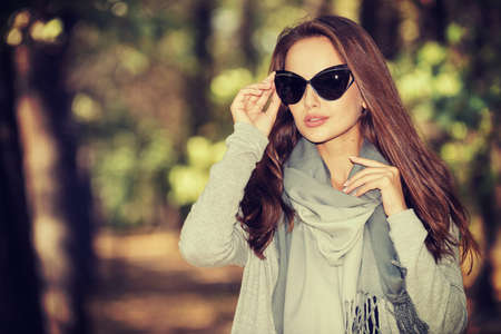 Beautiful smiling girl in stylish fashion clothes in autumn Park.  Beautiful woman outdoors in sunny day.の写真素材