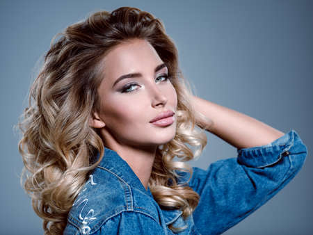 Photo of a beautiful young blond girl with curly hair. Closeup attractive sensual face of white...