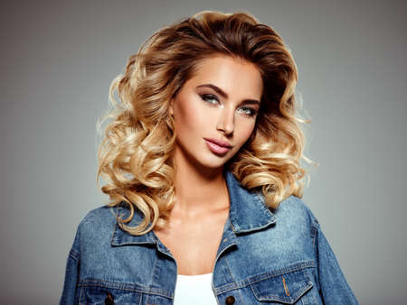 Photo of a beautiful young blond girl with curly hair. Closeup attractive sensual face of white...
