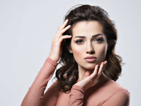 Portrait of brunette woman with beautiful long brown hair.  Pretty young adult girl posing at studio. Closeup attractive female face. の写真素材