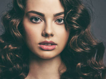 Closeup face of a beautiful woman with a smoky eye makeup. Sexy and gorgeous brown-haired woman with...
