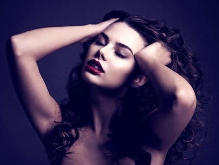 Sexy beautiful woman with a red lipstick and a smoky eye makeup. Sensual and gorgeous brown-haired...
