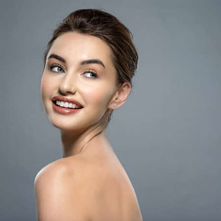 Happy  beautiful young brunette woman with clean face. Beautiful face of  a smiling  caucasian model...