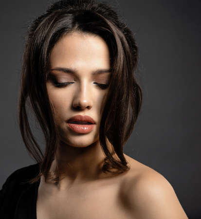 Beautiful woman with brown hair. Attractive model with brown eyes. Fashion model with a smokey...