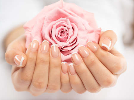 Woman gets manicure procedure in a spa salon. Beautiful female hands. Hand care. Woman cares for the nails on hands. Beauty treatment with skin of hand.   Woman's hands close-up view.の写真素材