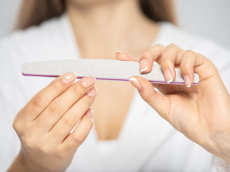 Woman gets manicure procedure in a spa salon. Beautiful female hands. Hand care. Woman cares for the nails on hands. Beauty treatment with skin of hand.   Woman's hands close-up view.の写真素材