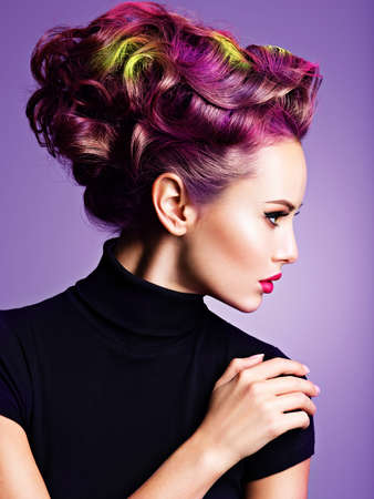 Beautiful girl with a stylish hairstyle. Profile portrait of a Fashion model with multicolor hair - posing at studioの写真素材
