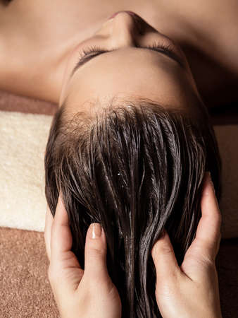 Cosmetologist massaging hair on the head of the woman. Spa treatments. Beauty treatment. Spa salonの写真素材