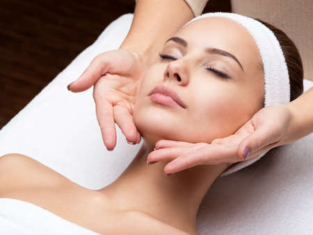 Masseur doing massage the head of an adult woman in the spa salonの写真素材