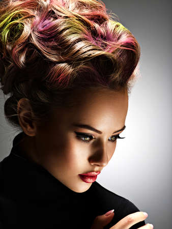 Beautiful woman with a stylish hairstyle. Fashion model with multicolor hair - posing at studioの写真素材