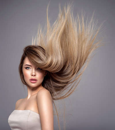 Young woman with long straight hair. Sexy and gorgeous blonde woman. Portrait of an attractive female posing at studio. Closeup face of a beautiful girl with makeup smoky eyes.の写真素材